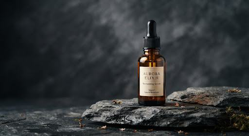 Example amber serum bottle standing on charcoal stone with dramatic side lighting